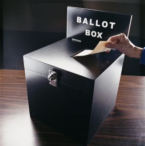 Man Inserting Voting Paper into a Ballot Box