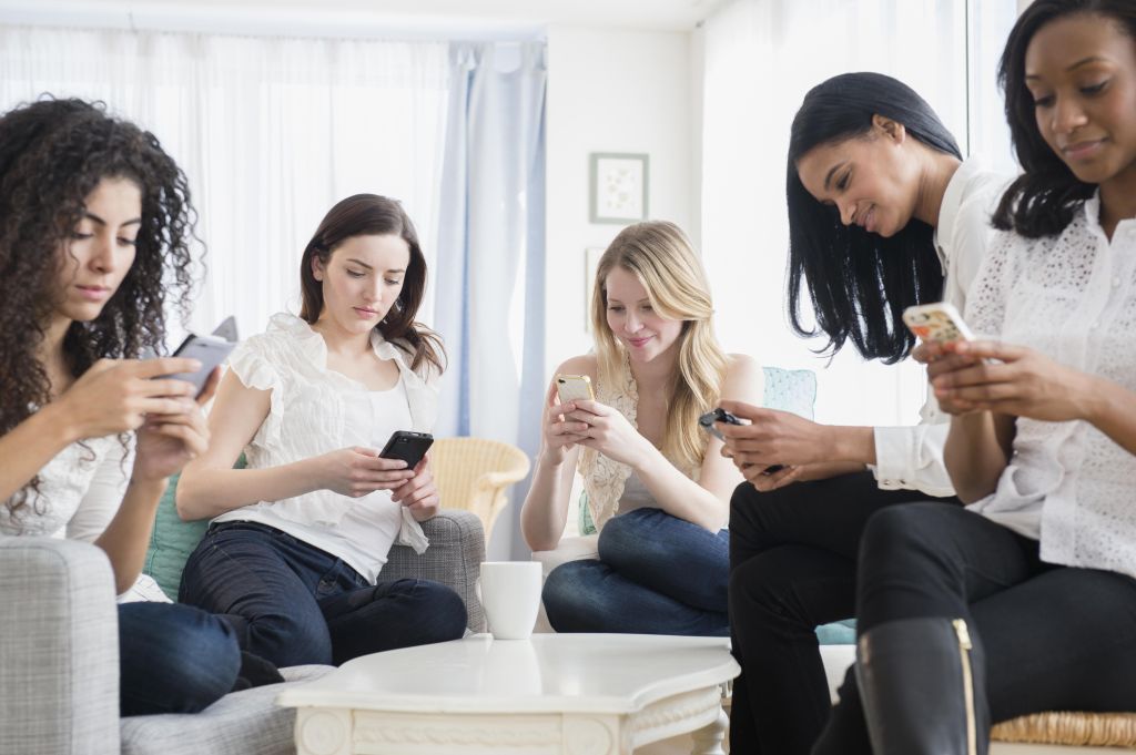 Women using cell phones in living room