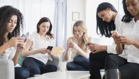 Women using cell phones in living room