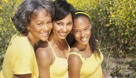 Grandmother, mother and daughter smiling near flowers