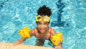 Girl with floaties and goggles in swimming pool